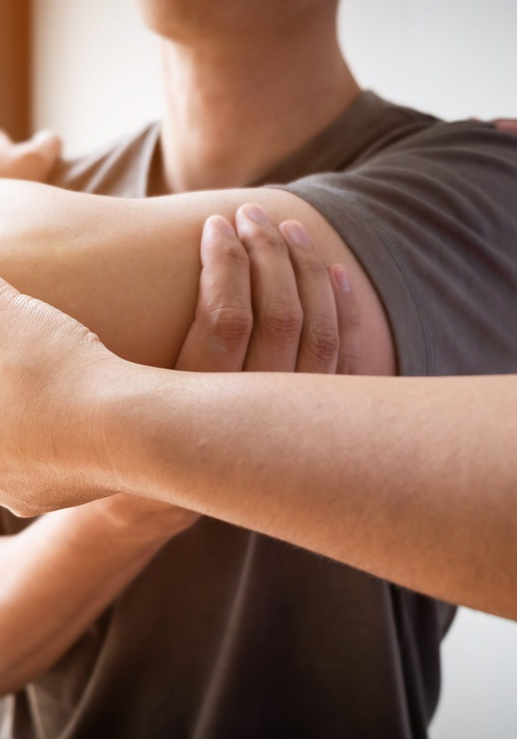 Therapist treating a male injured by rotator cuff stretching method, Physical therapy concept.